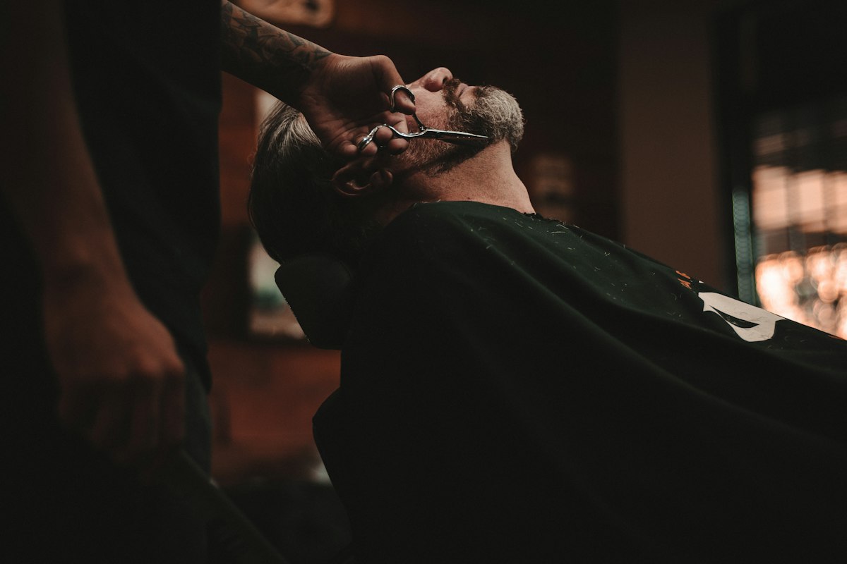 Steaming hot towel laid over a client's face before a straight razor shave