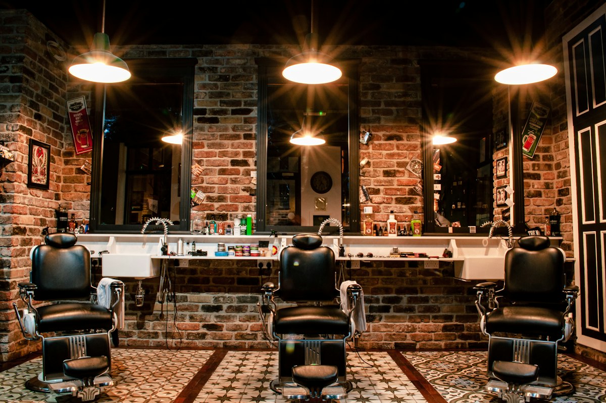 The barbershop seen through its front window from the sidewalk