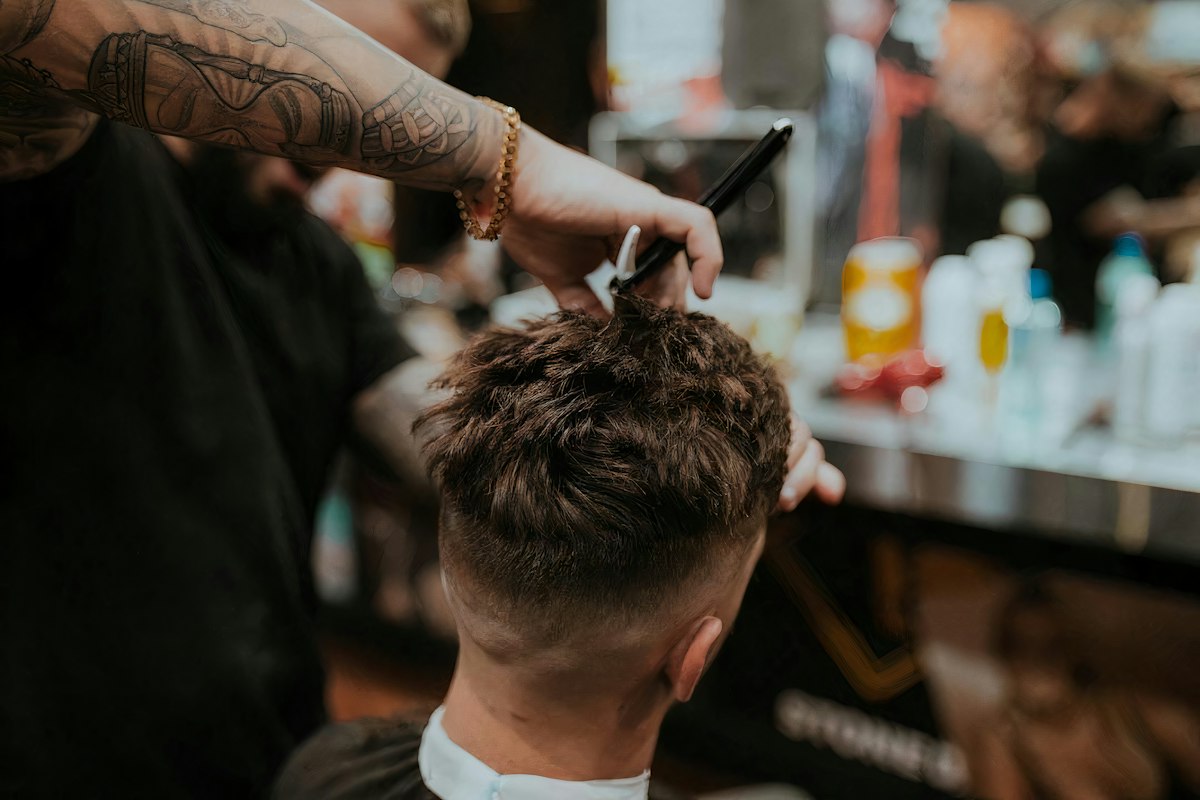 Clippers and combs lined up on the counter beside a spray bottle