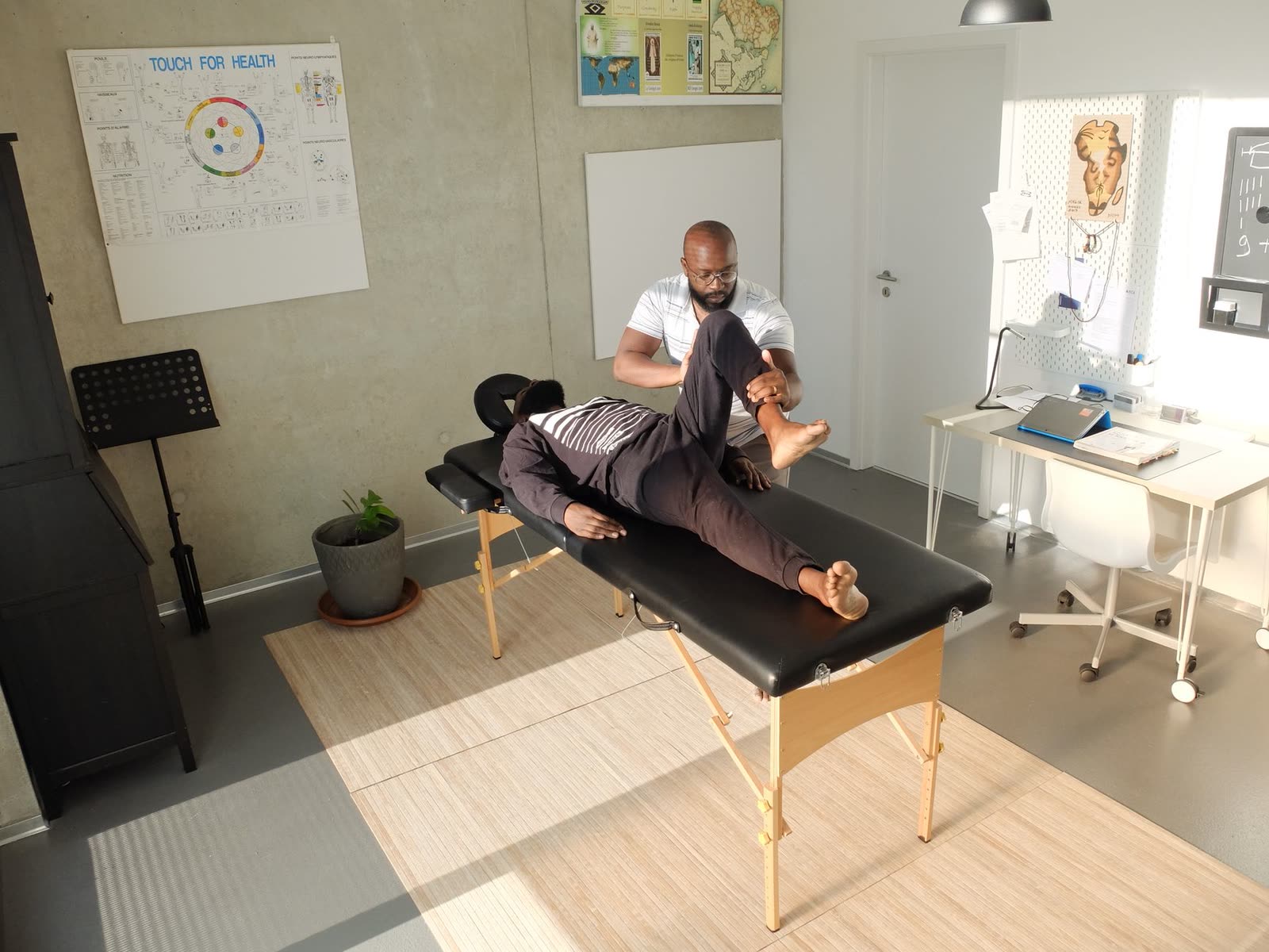 Chiropractor performing a spinal adjustment on a patient in a treatment room