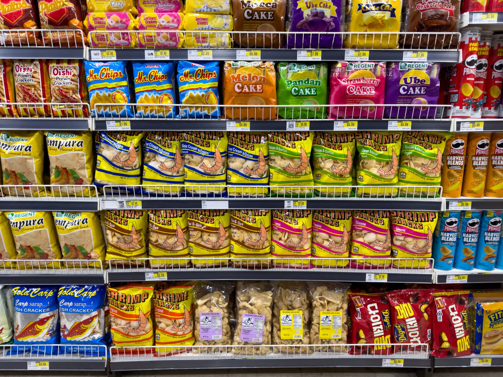 Bags of chips and a hot roller grill with taquitos at a convenience store counter